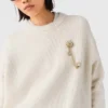 Jersey con broche floral Jersey con broche floral